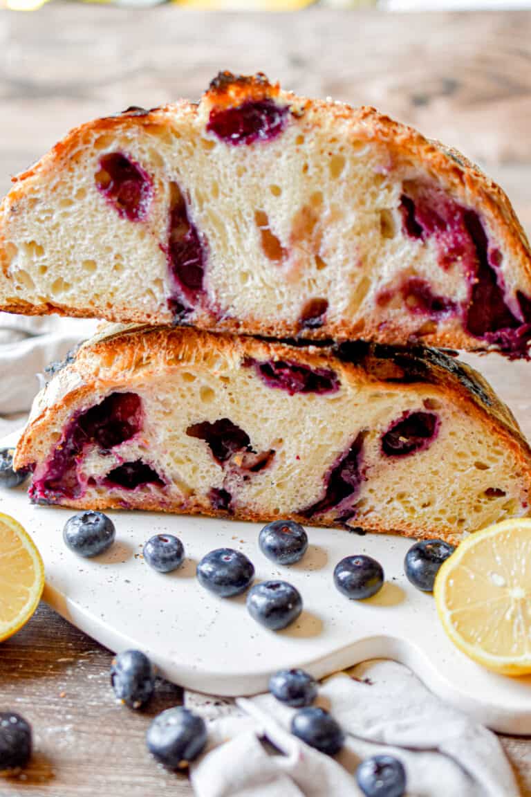 Two halves of the sourdough blueberry bread are on top of one another.