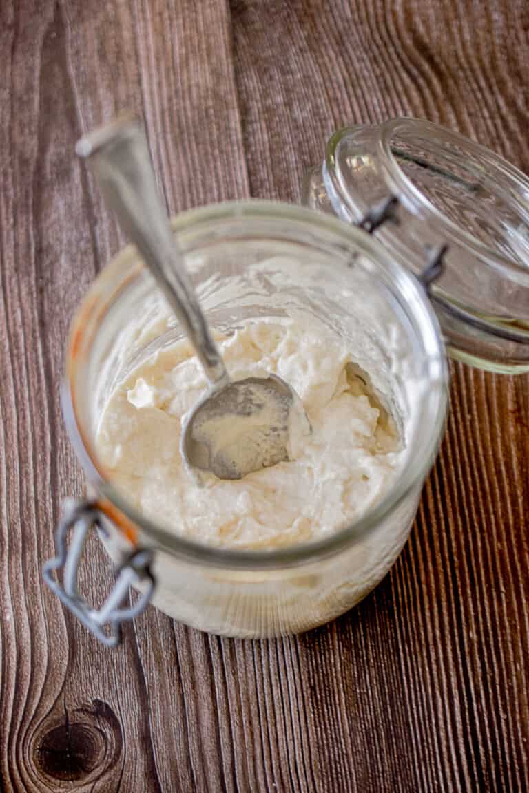 The ingredients for how to make a sourdough starter is in a glass jar.