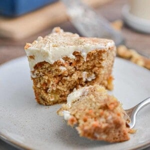 A piece of the sourdough discard carrot cake has a fork piece taken out of it.