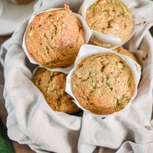 The sourdough discard zucchini muffins are piled high in a bowl.