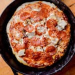 Pepperoni tops the sourdough pizza in a cast iron skillet.