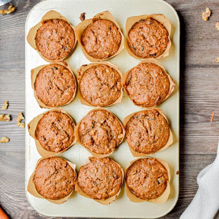 12 sourdough morning glory muffins are in a gold muffin tray.