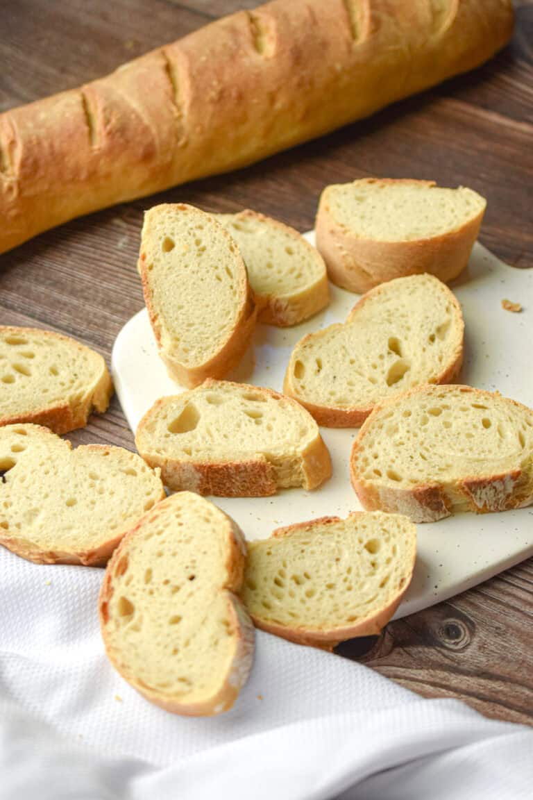 The slices of sourdough French bread are on a white cutting board.