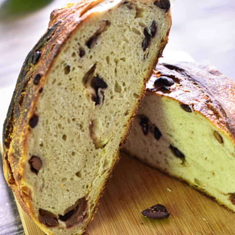 One half of the sourdough olive bread is leaning on top of the other sourdough olive bread.