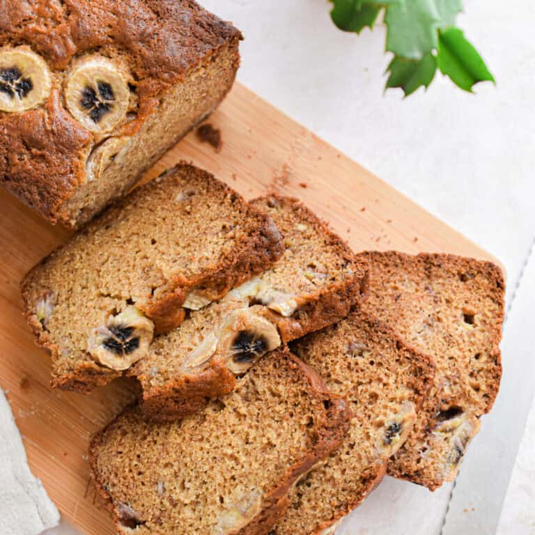 The banana bread with Greek yogurt is cut into 5 pieces on a cutting board.