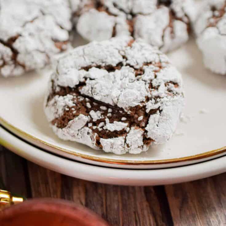 A sourdough chocolate crinkle cookie is on a white plate.