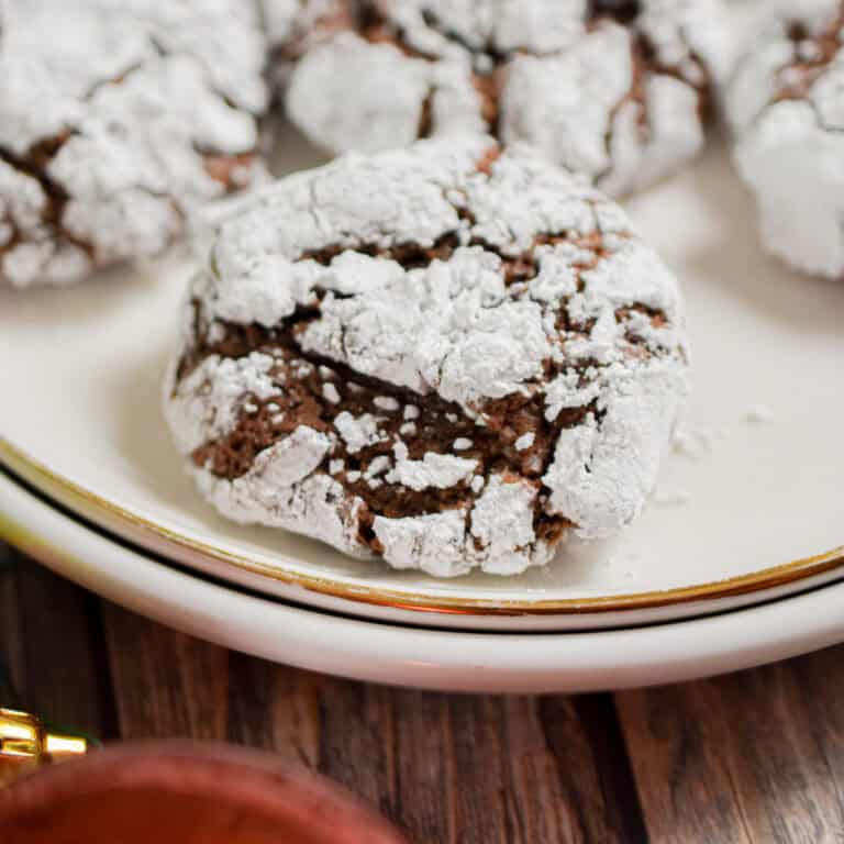 A sourdough chocolate crinkle cookie is on a white plate.