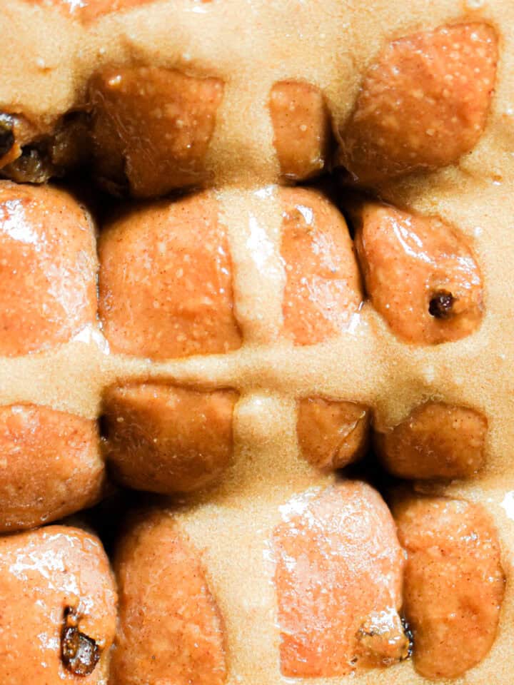 The sourdough hot cross buns are baked and shiny in the pan.