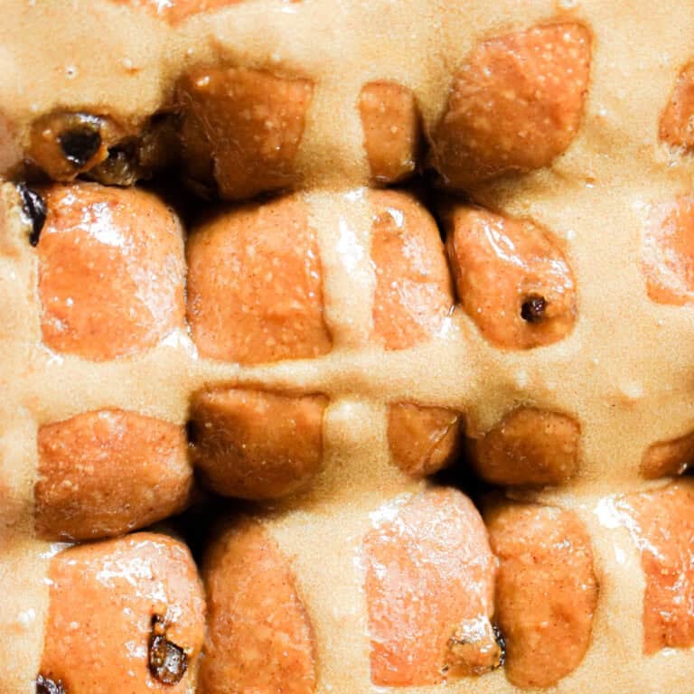 The sourdough hot cross buns are baked and shiny in the pan.