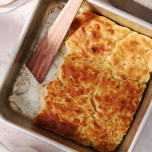 The butter swim biscuits are in a square pan with a wooden spoon.