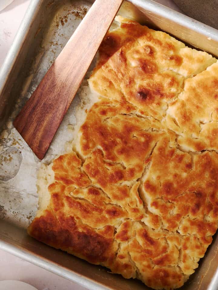 The butter swim biscuits are in a square pan with a wooden spoon.