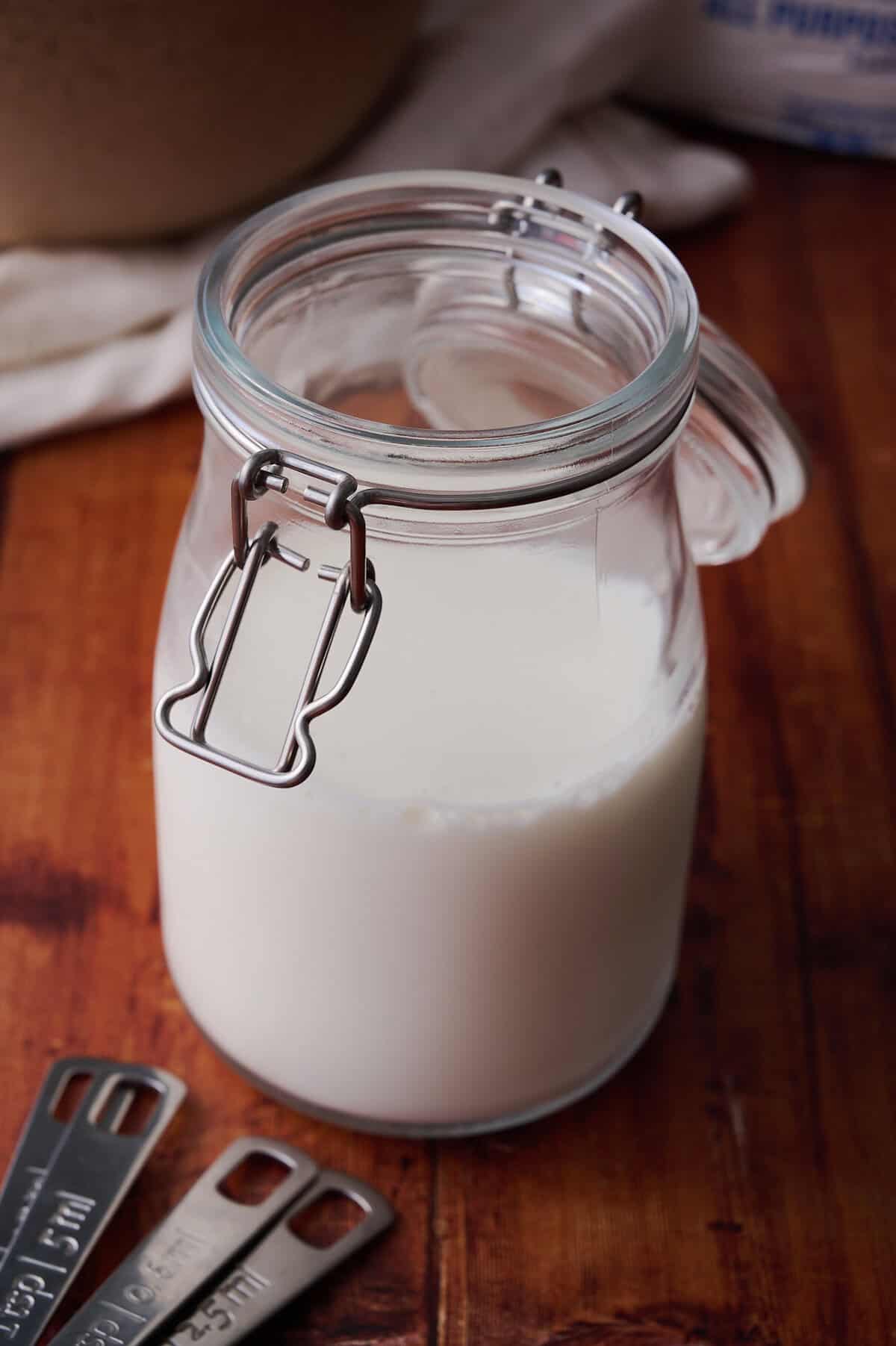 The buttermilk is in a small glass container with a bowl behind it.
