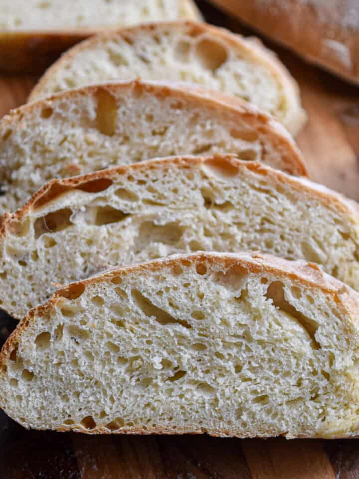 The sliced ciabatta bread are layered together to show the holes in the crumb.