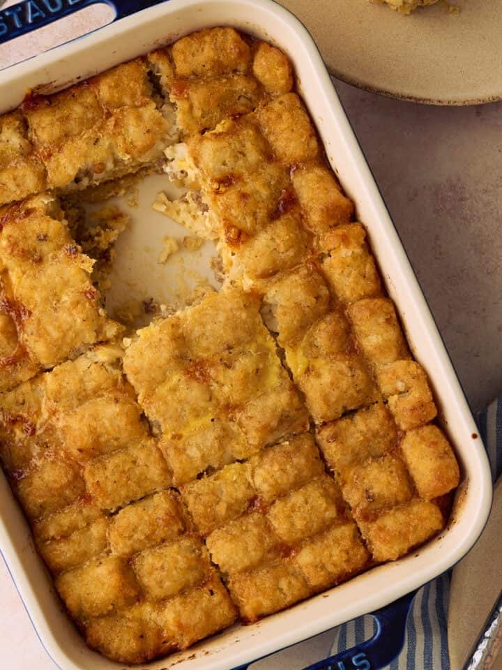 A square of the tater tot casserole is taken out of the baking dish.