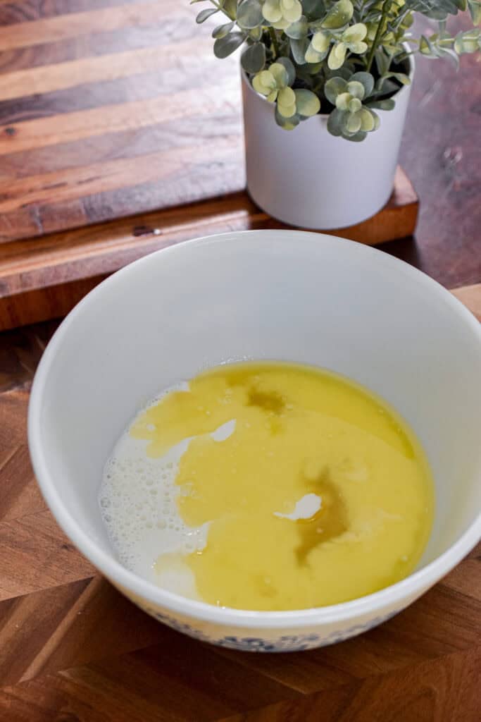 The melted butter, sugar, and milk are added to a large mixing bowl.