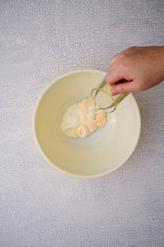 The vinegar is added to the bowl with the mayo and sour cream.