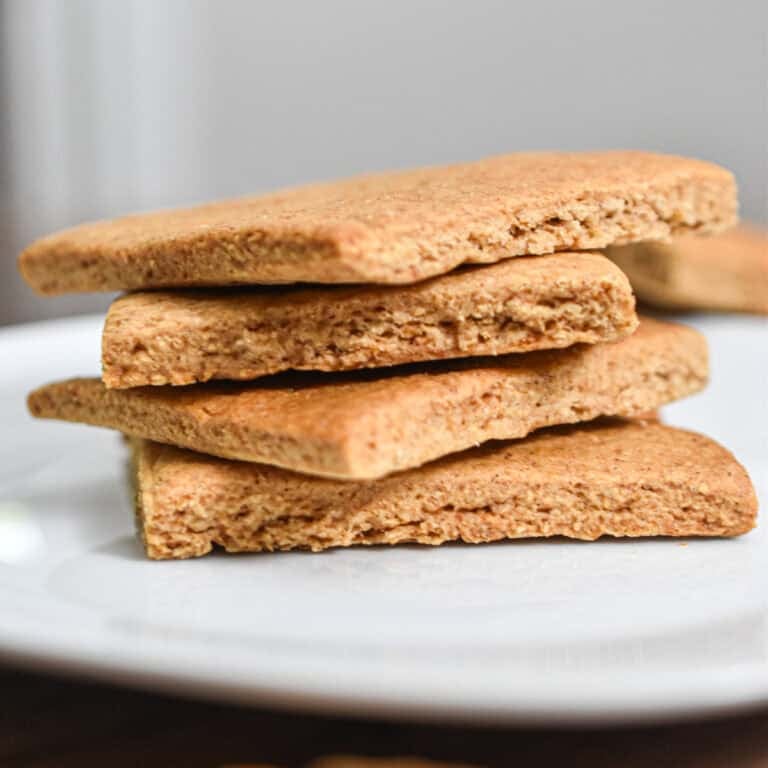 The sourdough graham crackers are stacked on top of each other on a white plate.