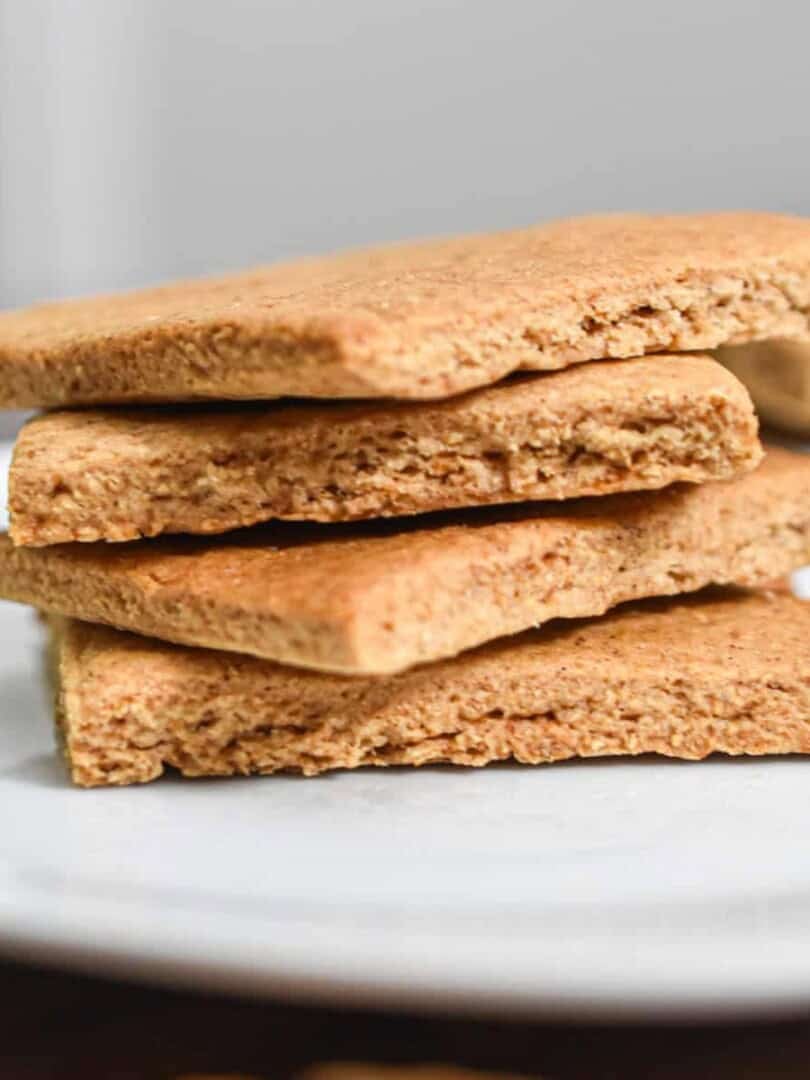 The sourdough graham crackers are stacked on top of each other on a white plate.