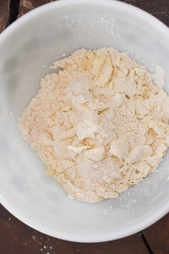 Flour mixture for strawberry muffins in a white bowl, ready for baking.