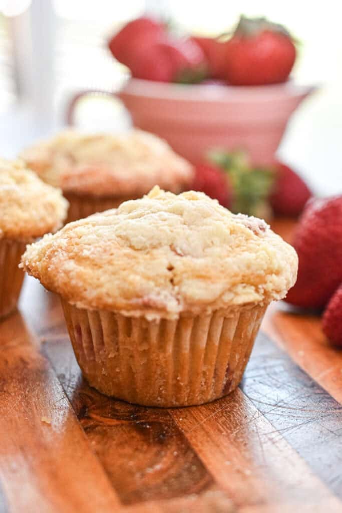The muffins are on a wooden cutting board.