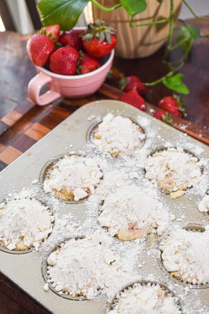 Fresh strawberry muffins with streusel in a muffin tin.