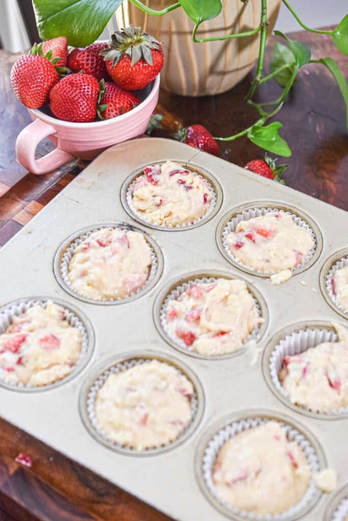 Strawberry muffins ready to bake in a muffin tin. 