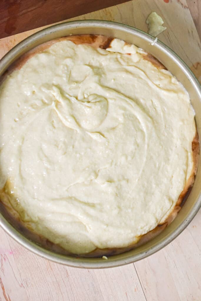 The batter is poured over the pineapple slices and maraschino cherries.