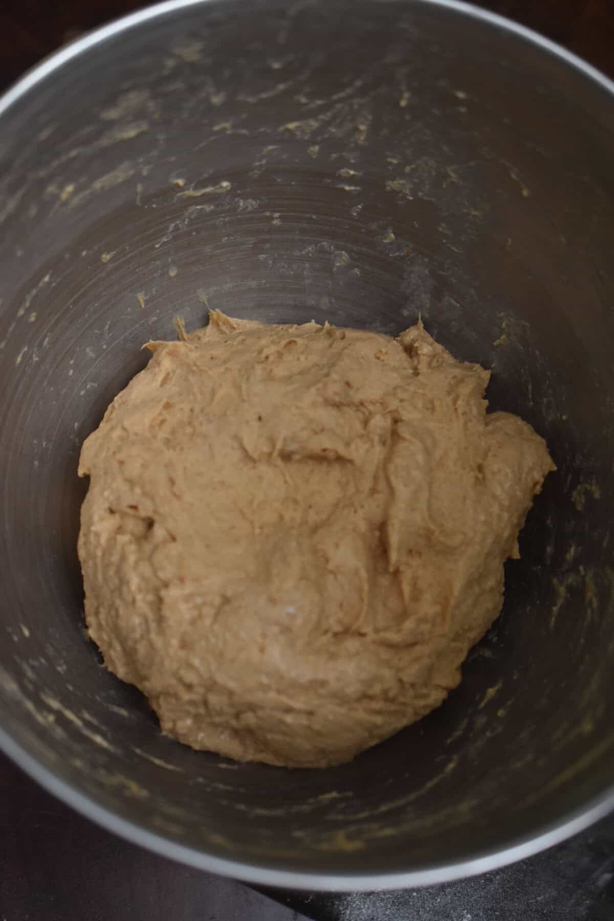 The sourdough discard pumpkin bagel dough is in a stand mixer bowl.