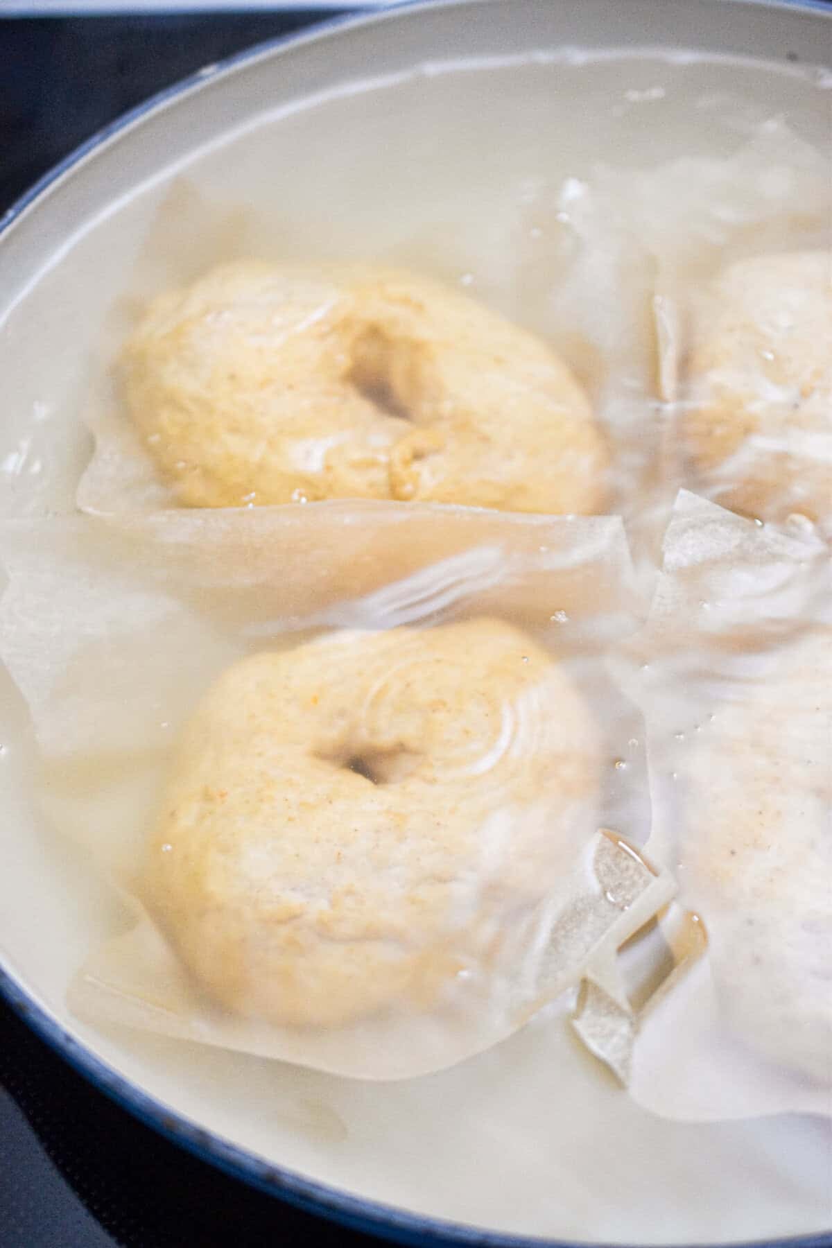 The bagels are boiling in a water bath.