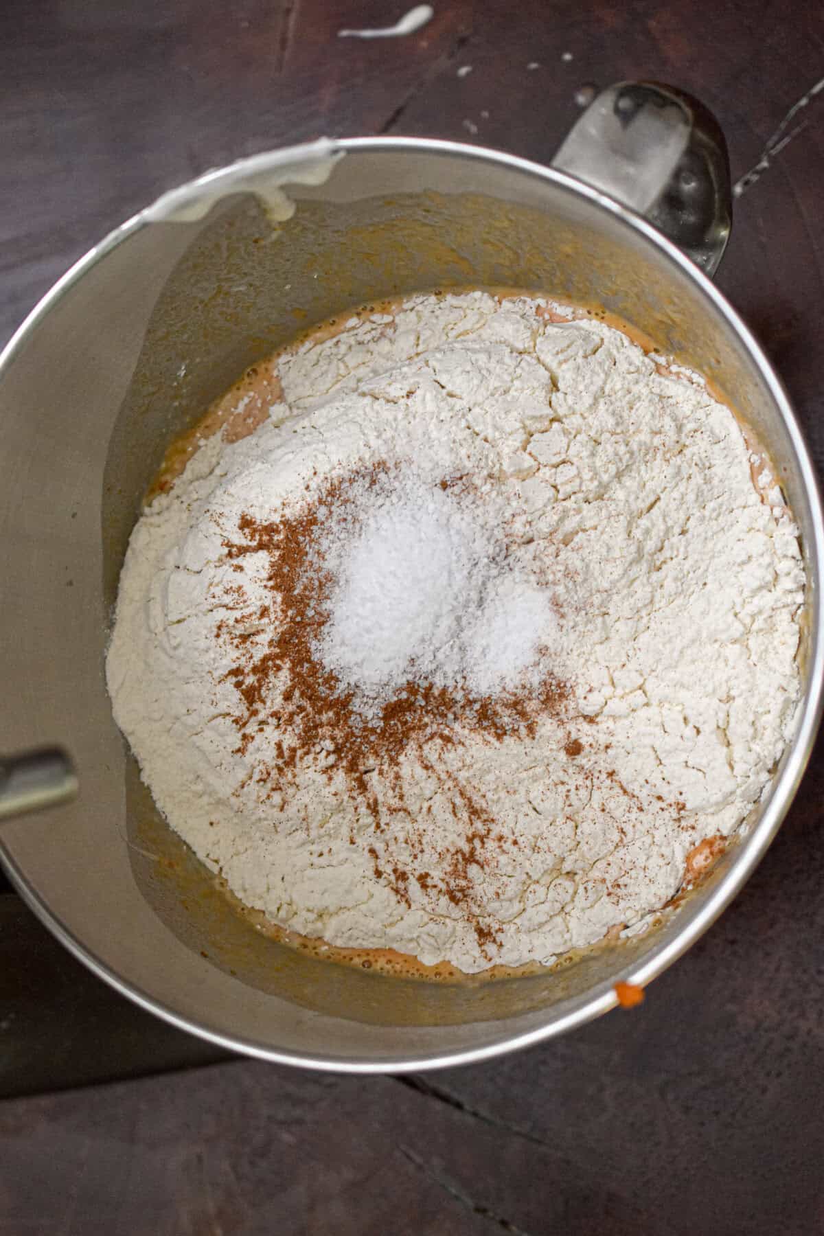 The dry ingredients are added to the bowl of a stand mixer.