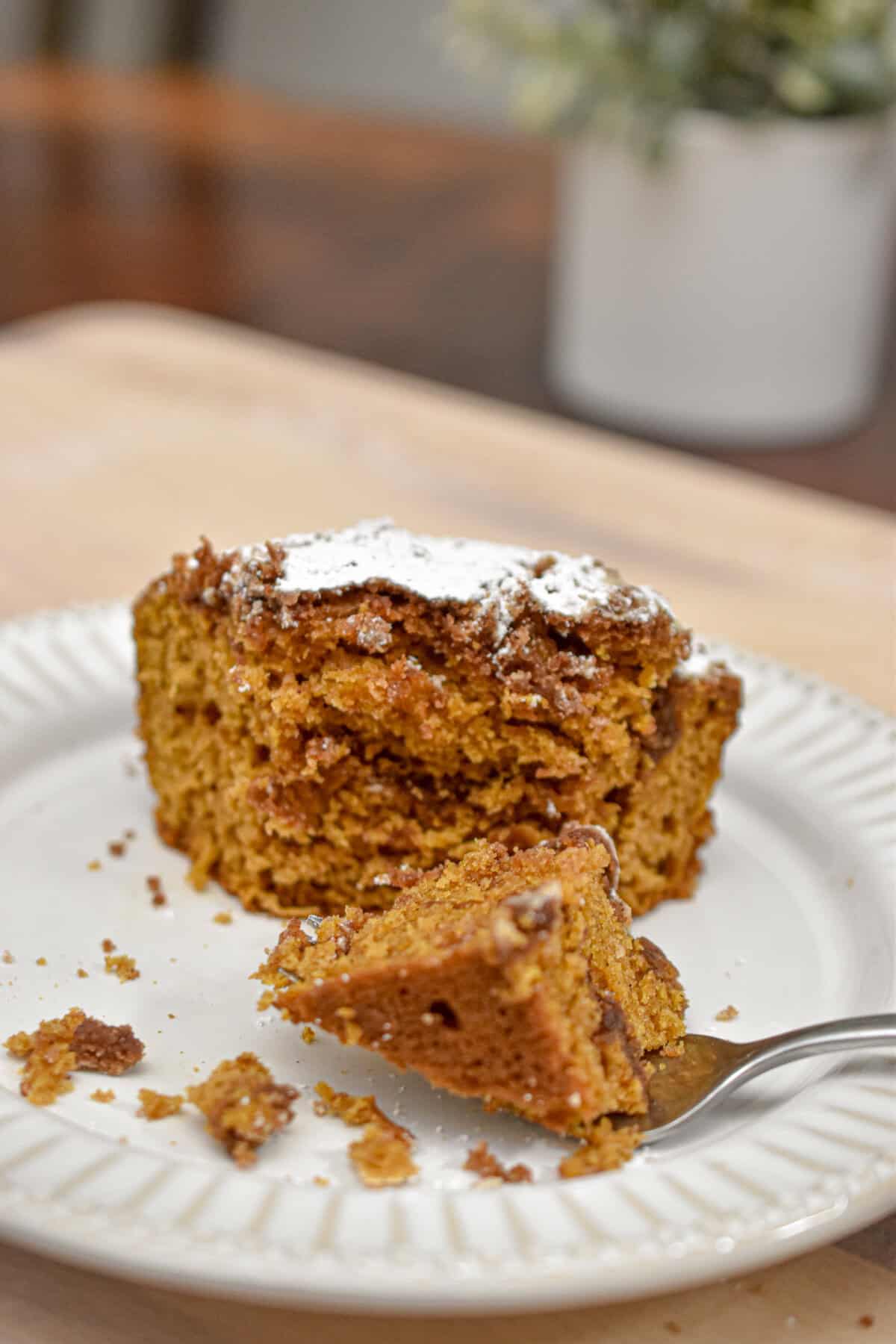 A fork has cut a piece of the sourdough pumpkin coffee cake on a plate.