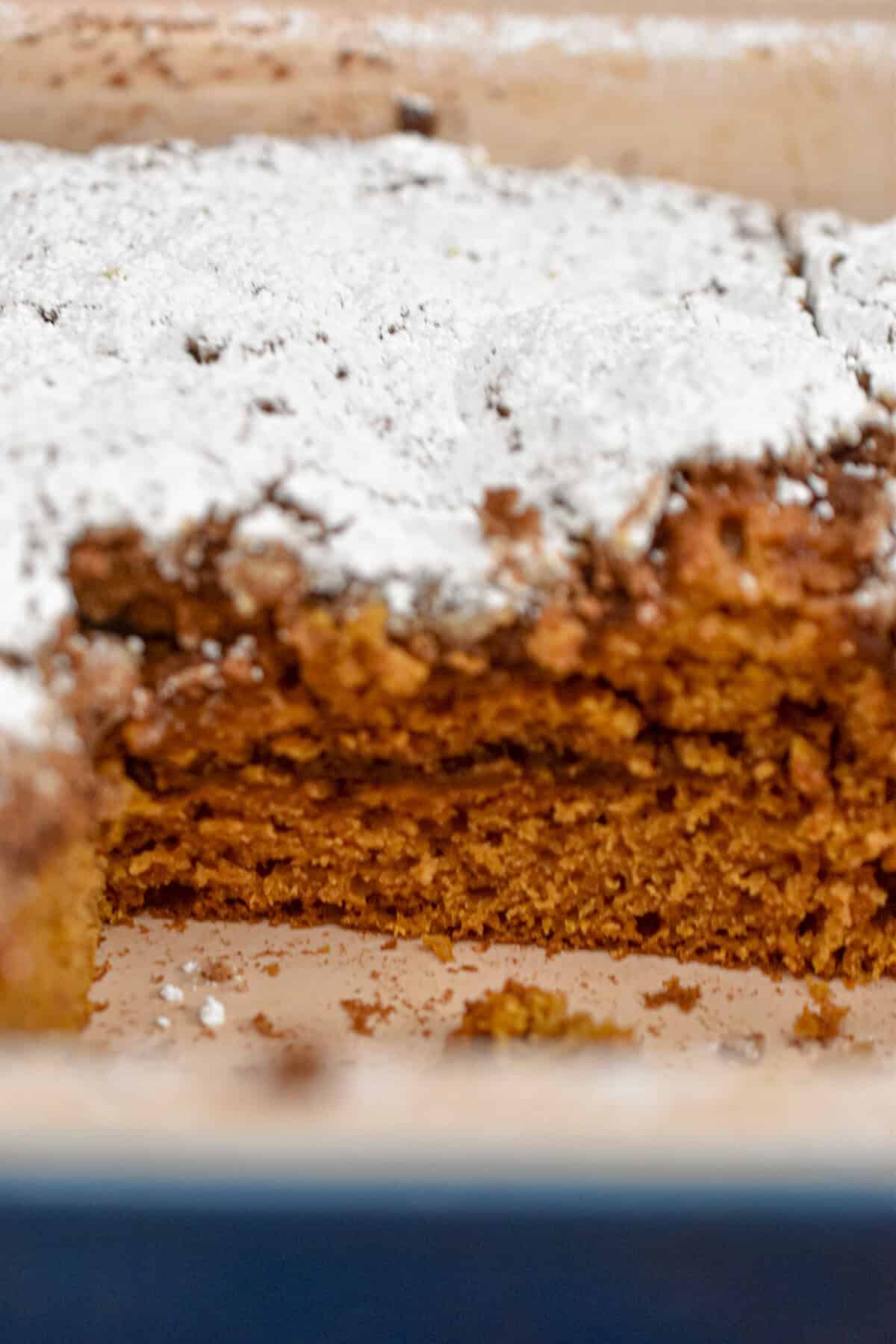The sourdough pumpkin coffee cake is in a blue pan and it is topped with powdered sugar.