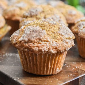 The pumpkin muffin with self rising flour is on a cutting board with more muffins in the background.