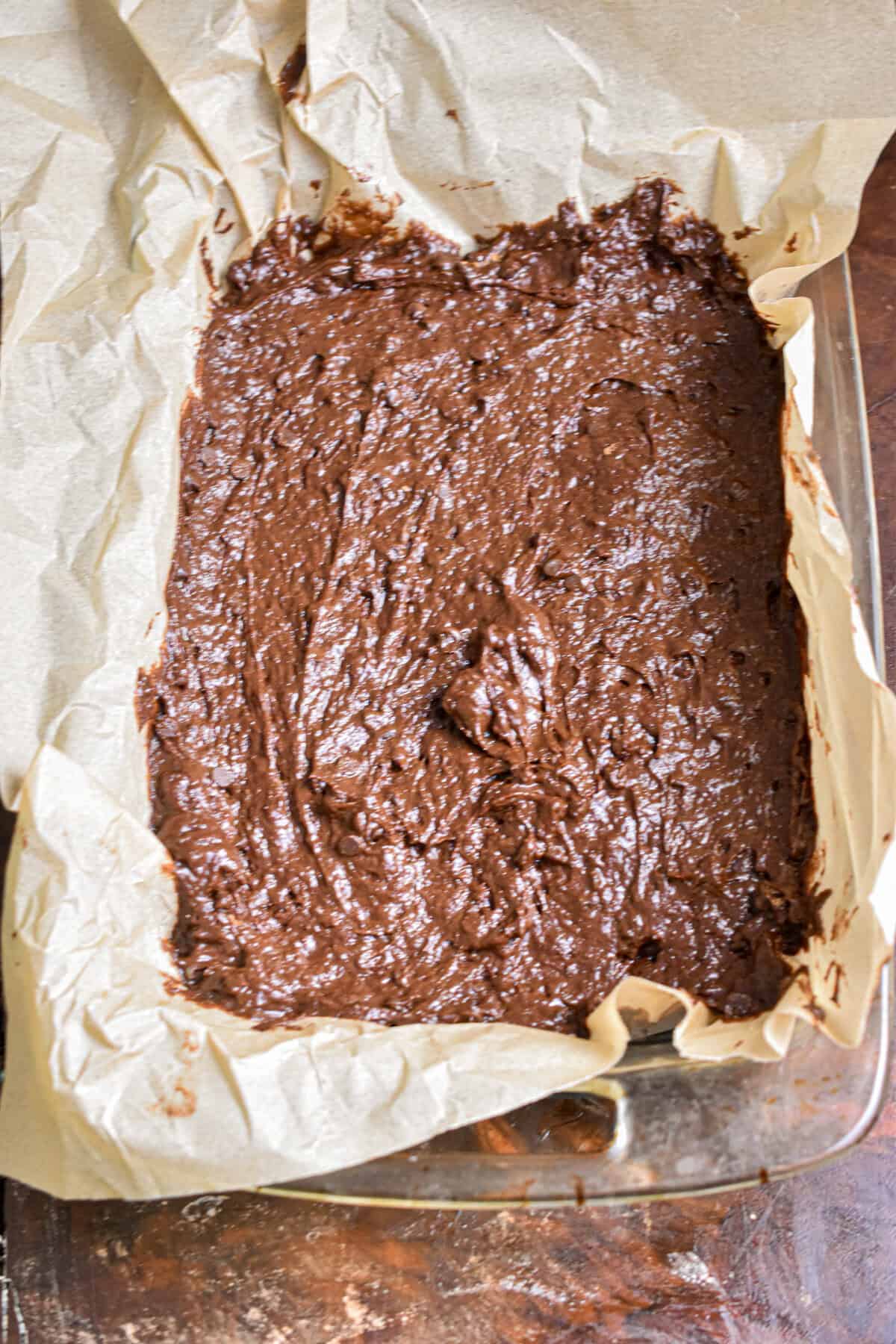 The brownie batter is poured into a baking dish.