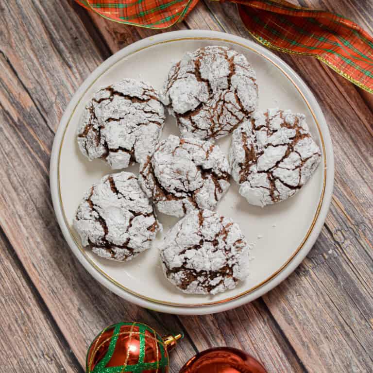 Sourdough Christmas cookies are on a white plate with a wooden background.