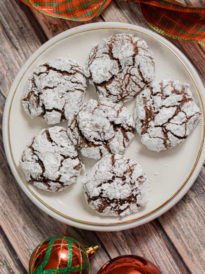 Sourdough Christmas cookies are on a white plate with a wooden background.