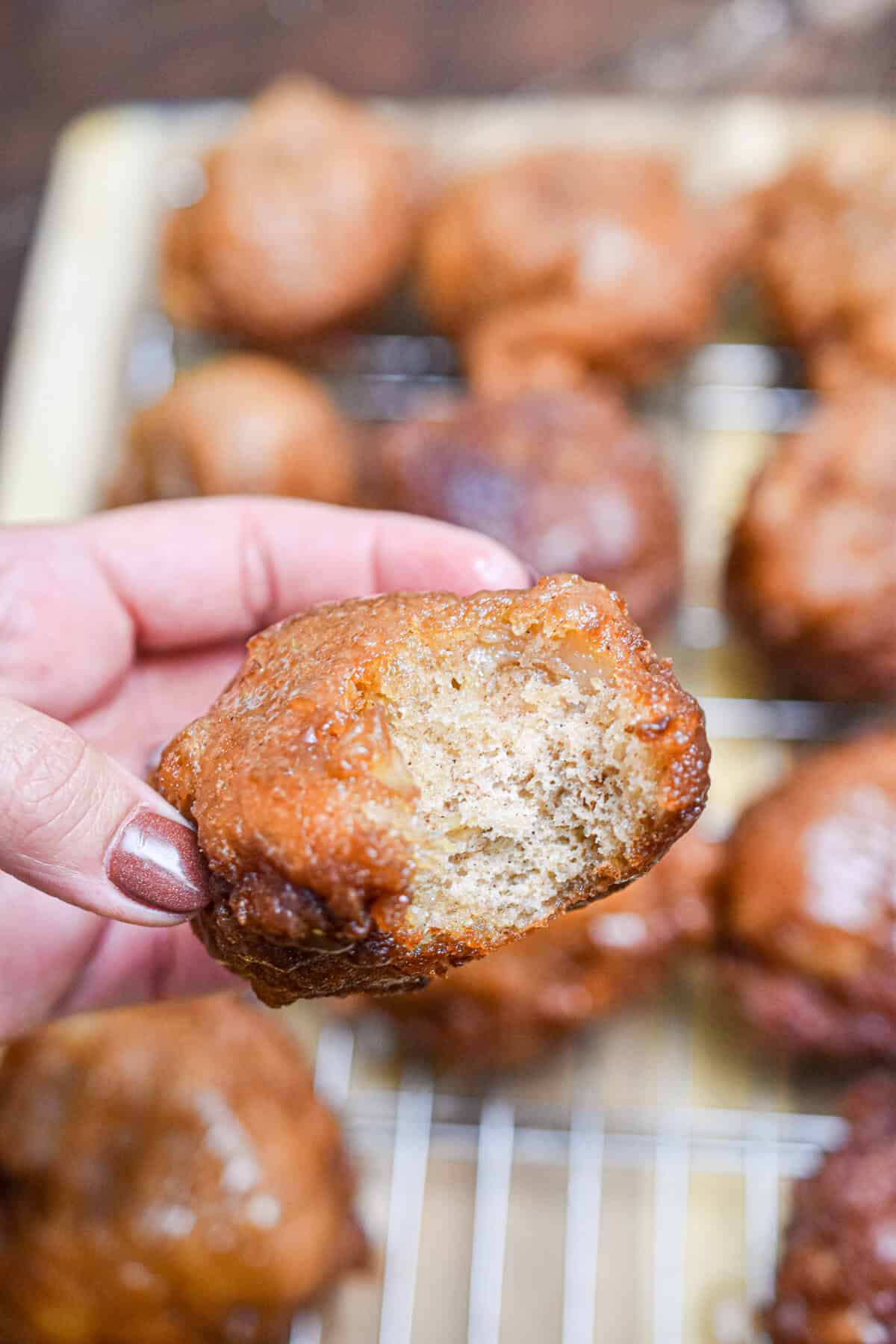 A bite is taken out of one of the apple fritters.