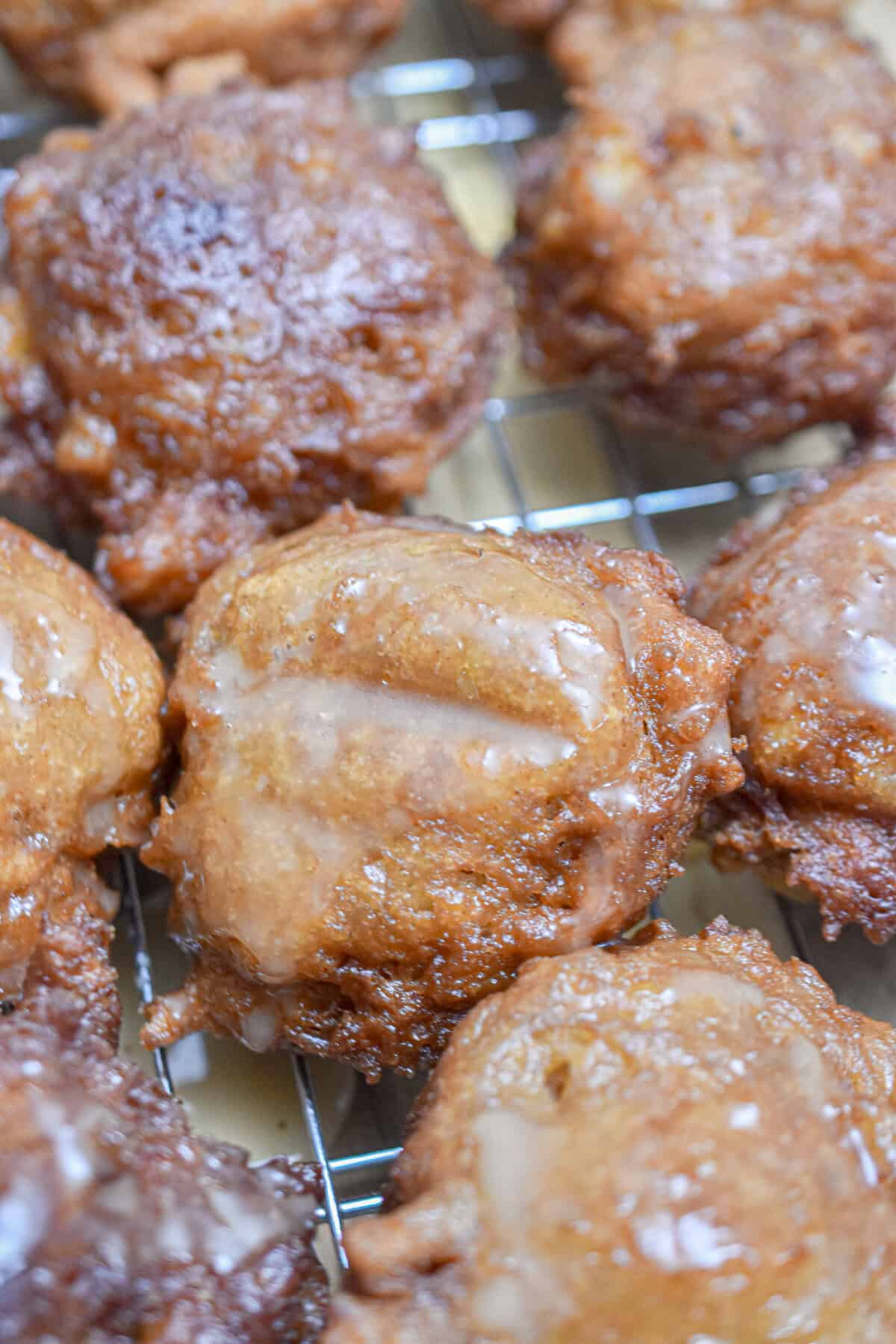 The sourdough discard apple fritters are on a wire rack.