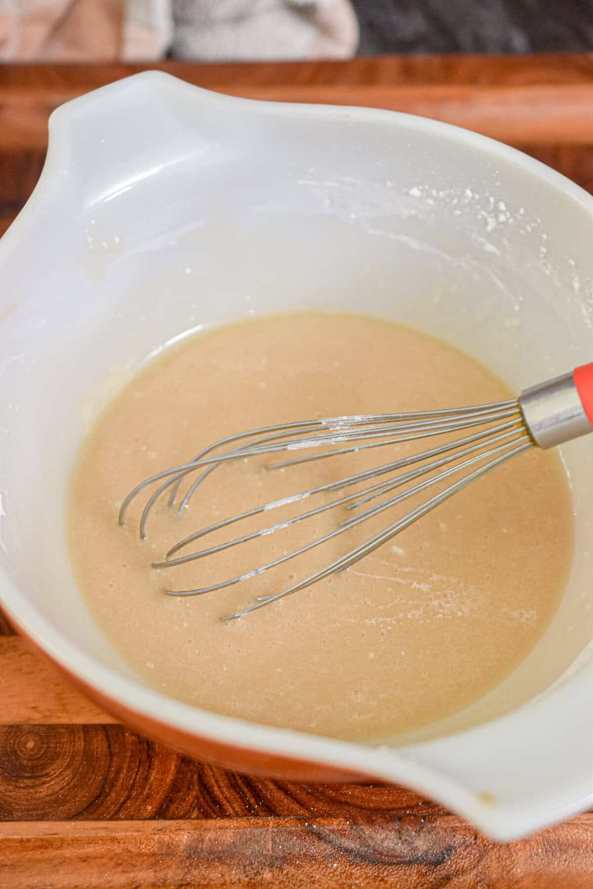 The glaze is in a bowl with a whisk.