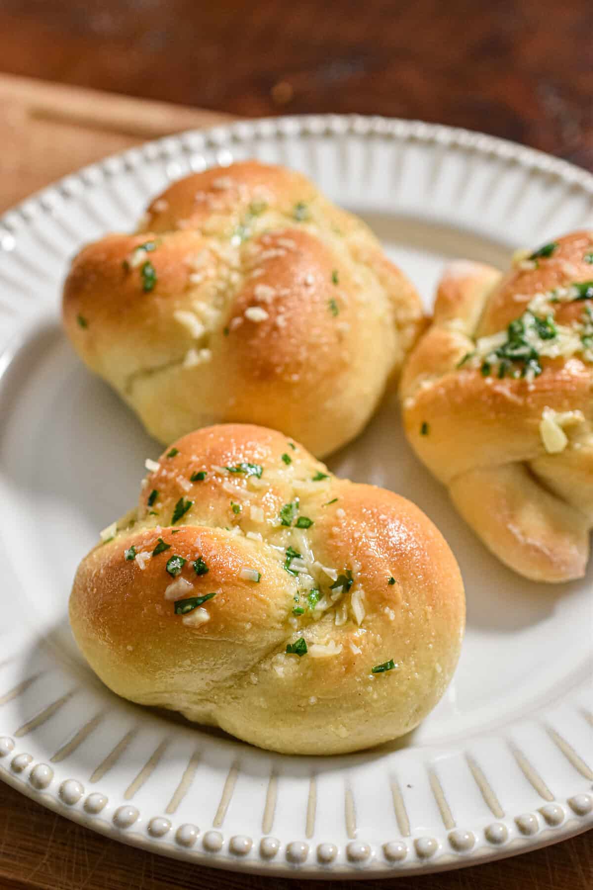 Three sourdough discard garlic knots are on a plate.