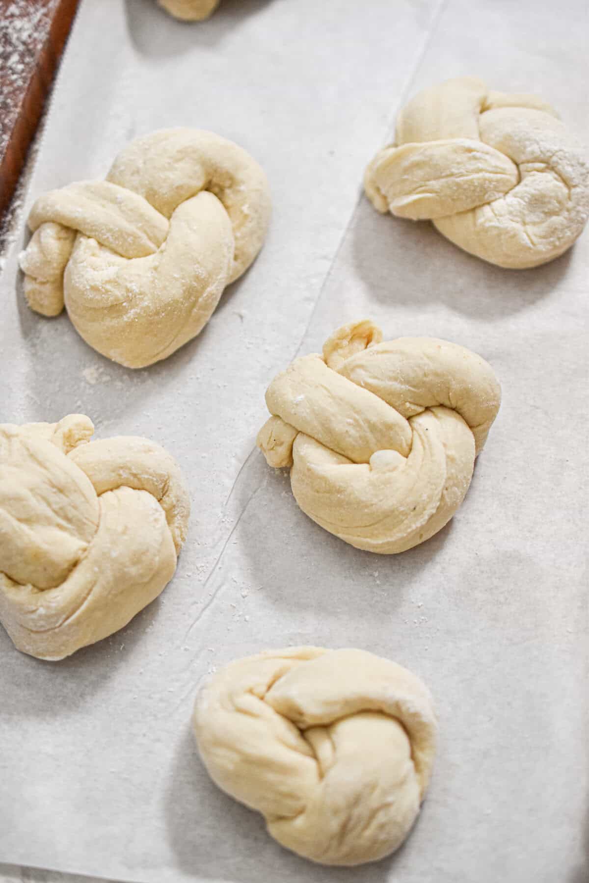 The sourdough discard garlic knots are on a parchment lined baking sheet.
