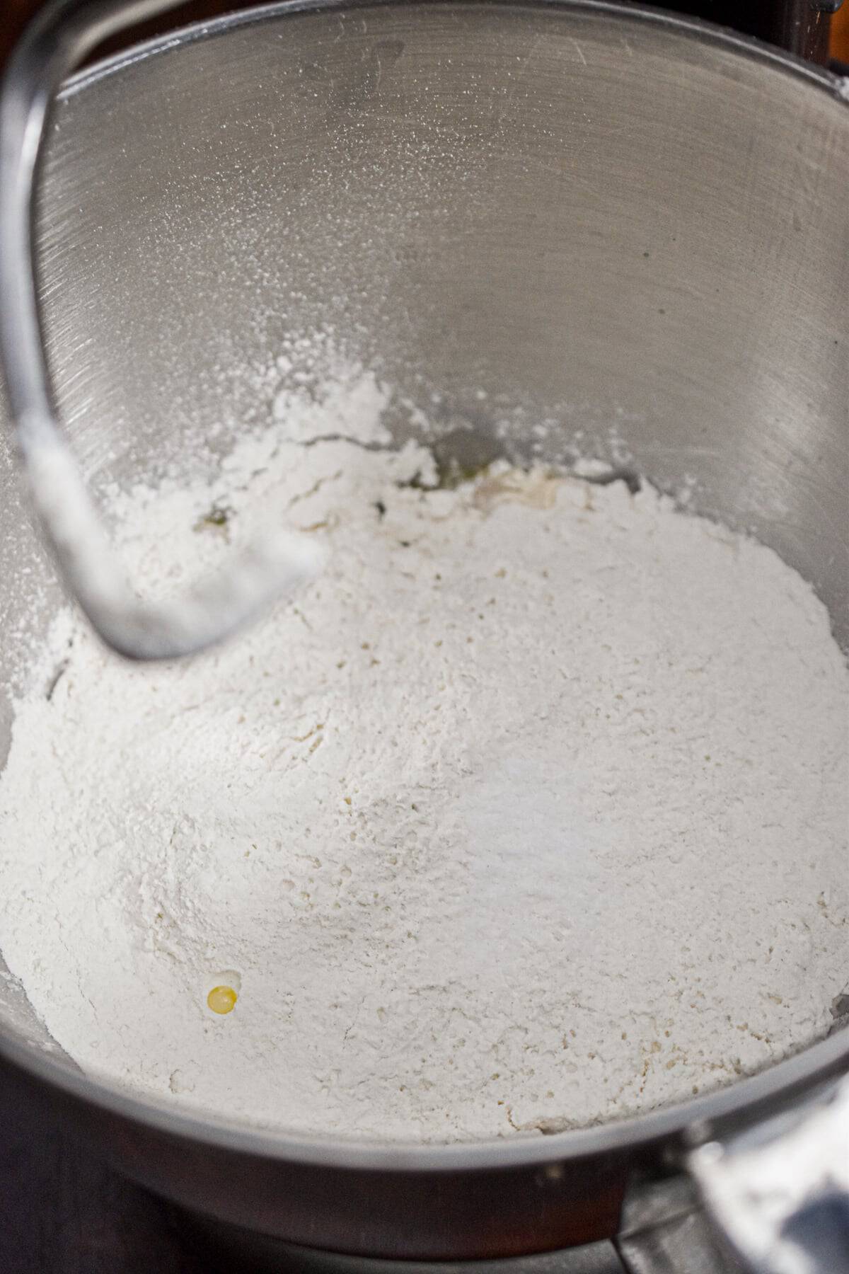 All the ingredients for the dough are in a stand mixer bowl.